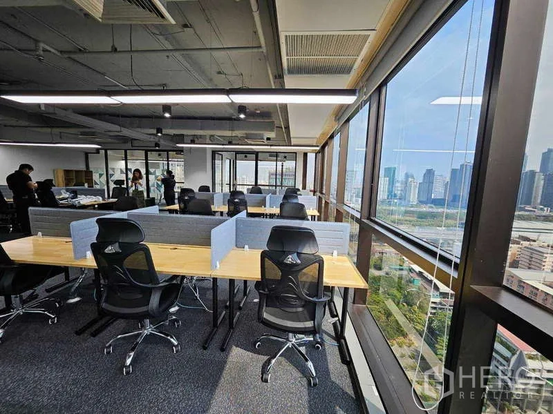 办公空间 出租在Ratchathewi, Bangkok - 一排人体工学椅与长桌，环绕窗景俯瞰曼谷天际线