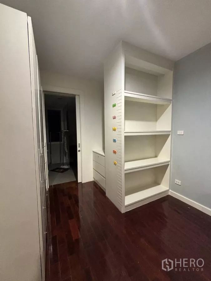 Detached House for rent in Bang Kapi, Bangkok - Room with tall white shelving and storage on dark wood flooring.