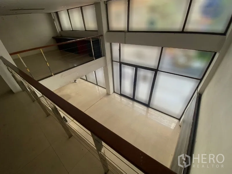 Retail Space for rent in Watthana, Bangkok - Double-height interior with mezzanine railing and frosted glass storefront.