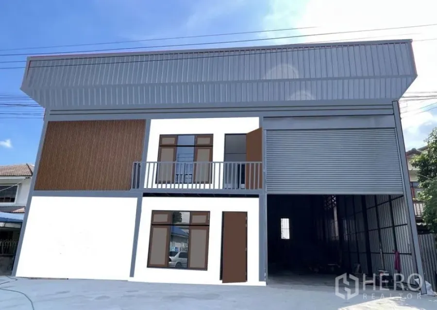 Warehouse for rent in Lam Luk Ka, Pathum Thani - Front elevation showing wide concrete forecourt and full-height roller shutter for truck access.