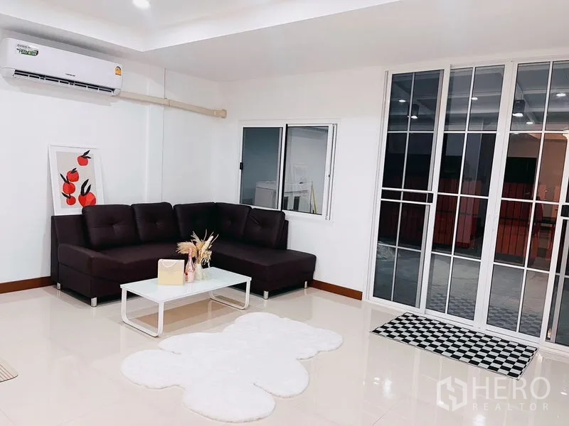 联排别墅 出租在Huai Khwang, Bangkok - 开放式起居区，带推拉落地门、窗户和壁挂空调。