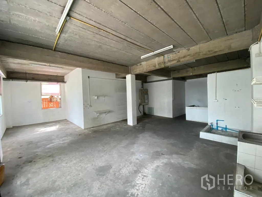 Retail Space for rent in Khlong Toei, Bangkok - Open concrete room with exposed beams, windows and utility connections.