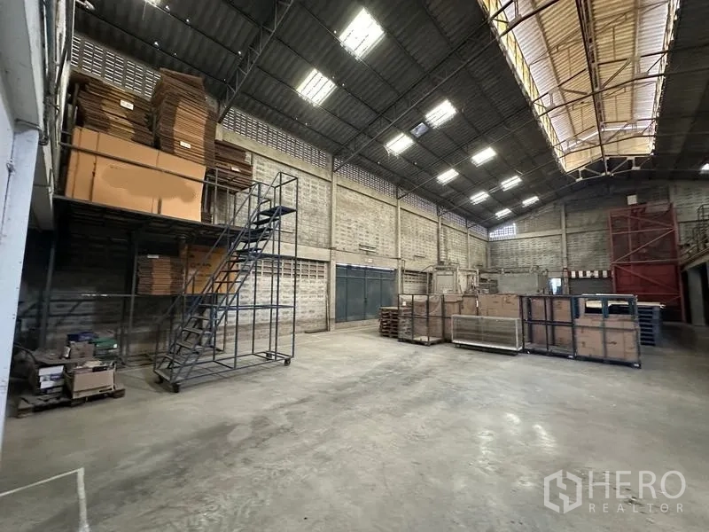 Factory for rent in Lam Luk Ka, Pathum Thani - Warehouse space with steel stair platform and boxed inventory.