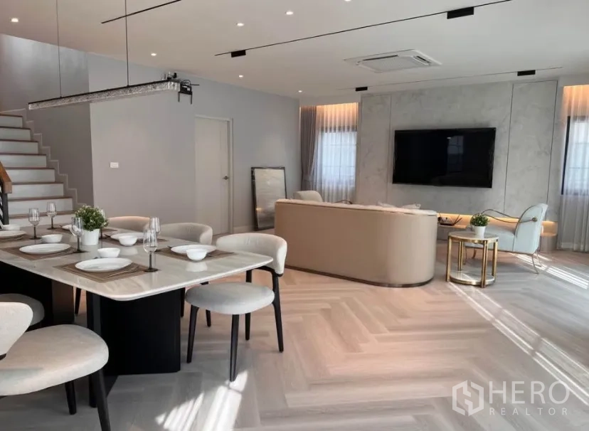 Detached House for rent in Bang Phli, Samut Prakan - Dining area overlooking the TV wall and staircase in a spacious open-plan interior.