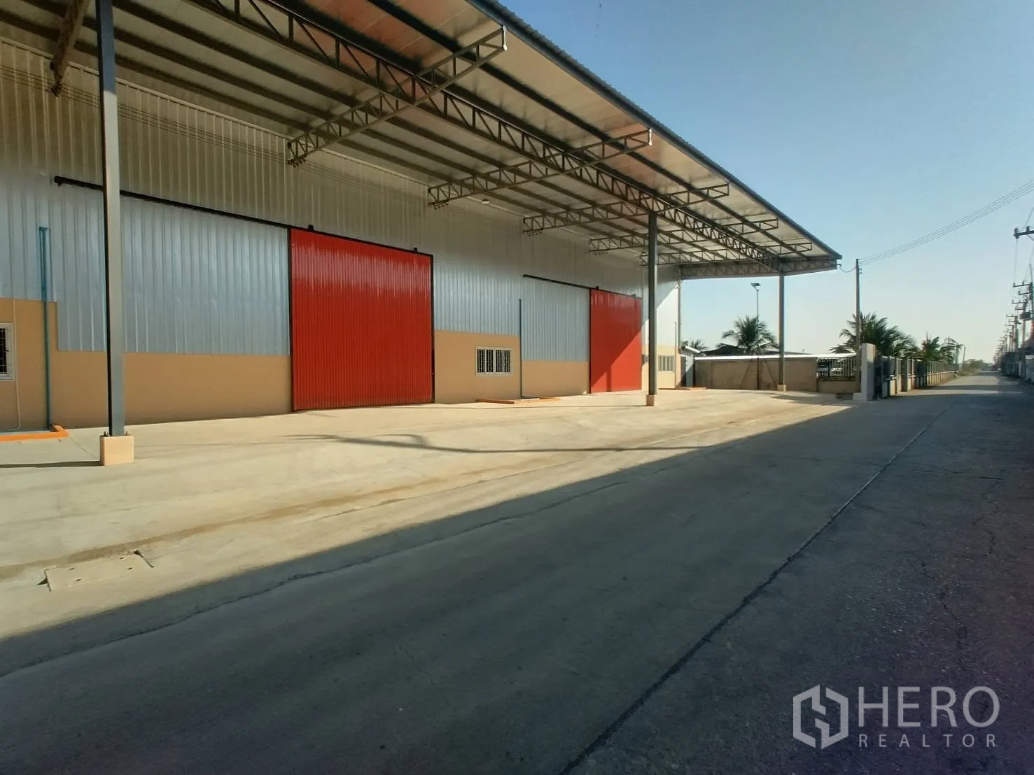Warehouse for rent in Khlong Luang, Pathum Thani - Long covered loading zone beside the access road with several sliding doors and ample maneuvering space.