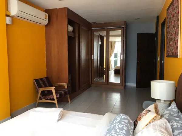 联排别墅 出租在Khlong Toei, Bangkok - 主卧，黄色墙面与内置木衣柜。