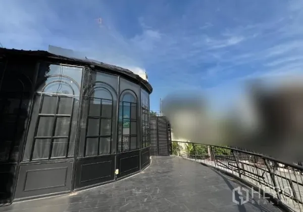 零售空间 出租 - 玻璃拱窗立面侧视图，配有宽阔露台步道与护栏。