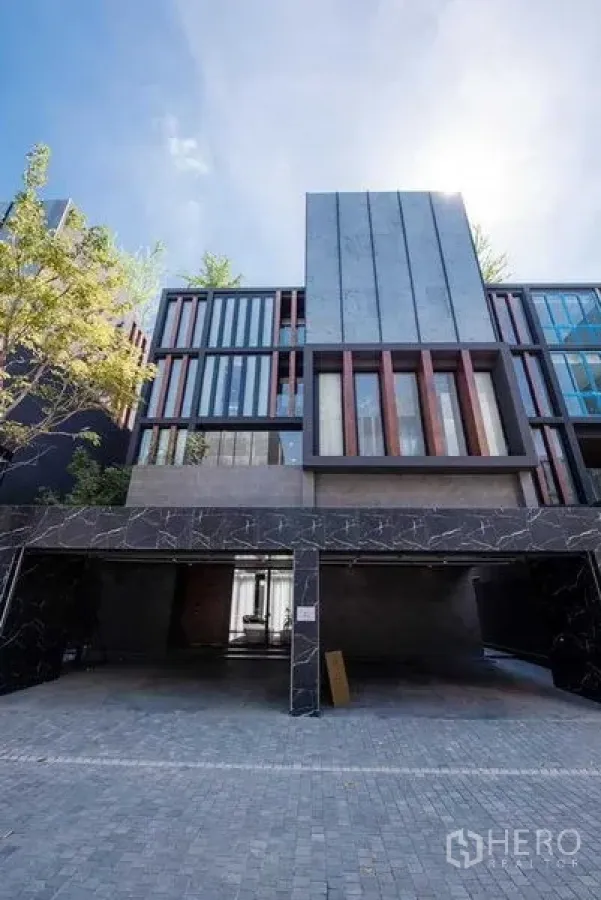 Detached House for sale in Prawet, Bangkok - Street‑level view showing two‑car covered garage and tall vertical windows.