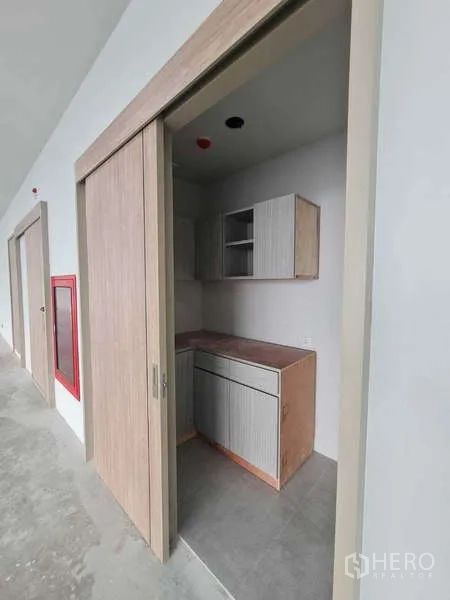 Office Space for rent in Chatuchak, Bangkok - Compact pantry with built‑in cabinets and a sliding wooden door.