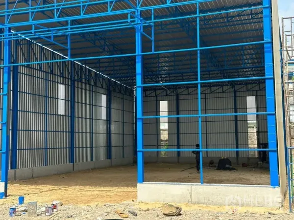Warehouse for rent in Wang Thonglang, Bangkok - New-build warehouse with blue steel frame, high gabled roof and corrugated metal walls on a concrete base.
