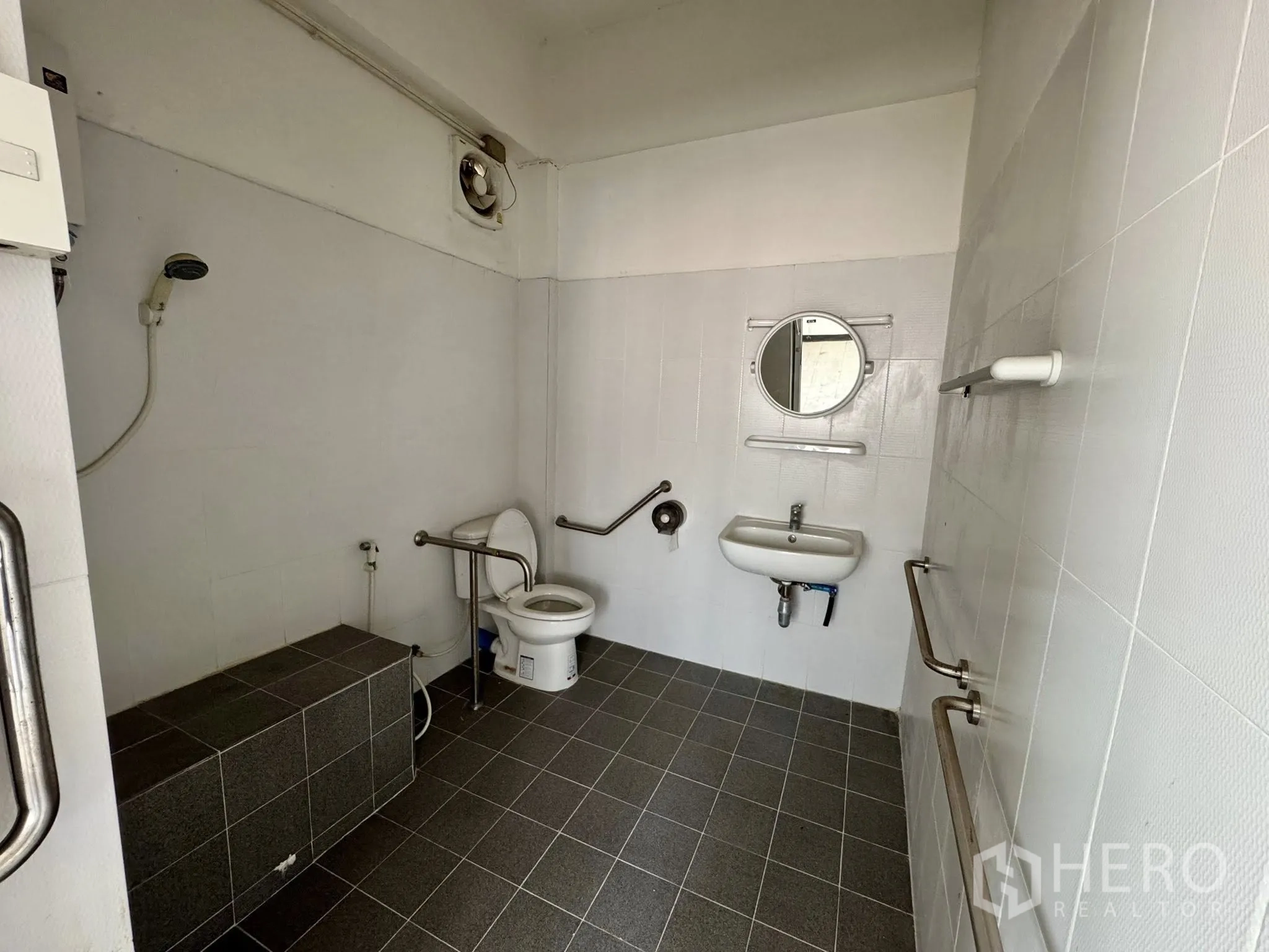 Warehouse for rent in Mueang Samut Sakhon, Samut Sakhon - Accessible bathroom with grab bars, shower and gray floor tiles.