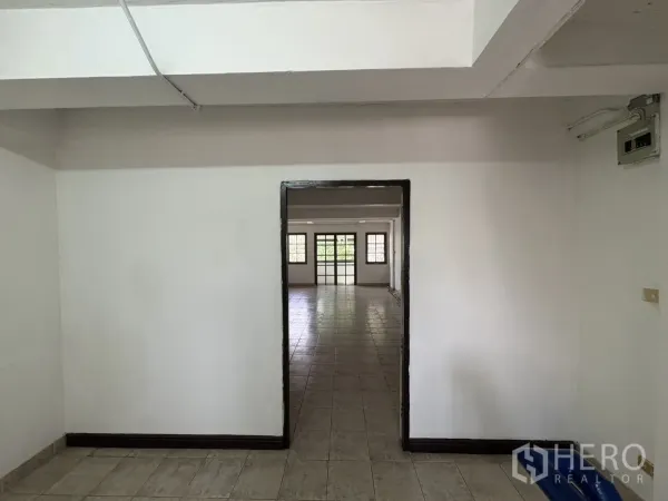 Shophouse for rent in Phra Khanong, Bangkok - Doorway leading to a bright, spacious room with tiled flooring and windows.