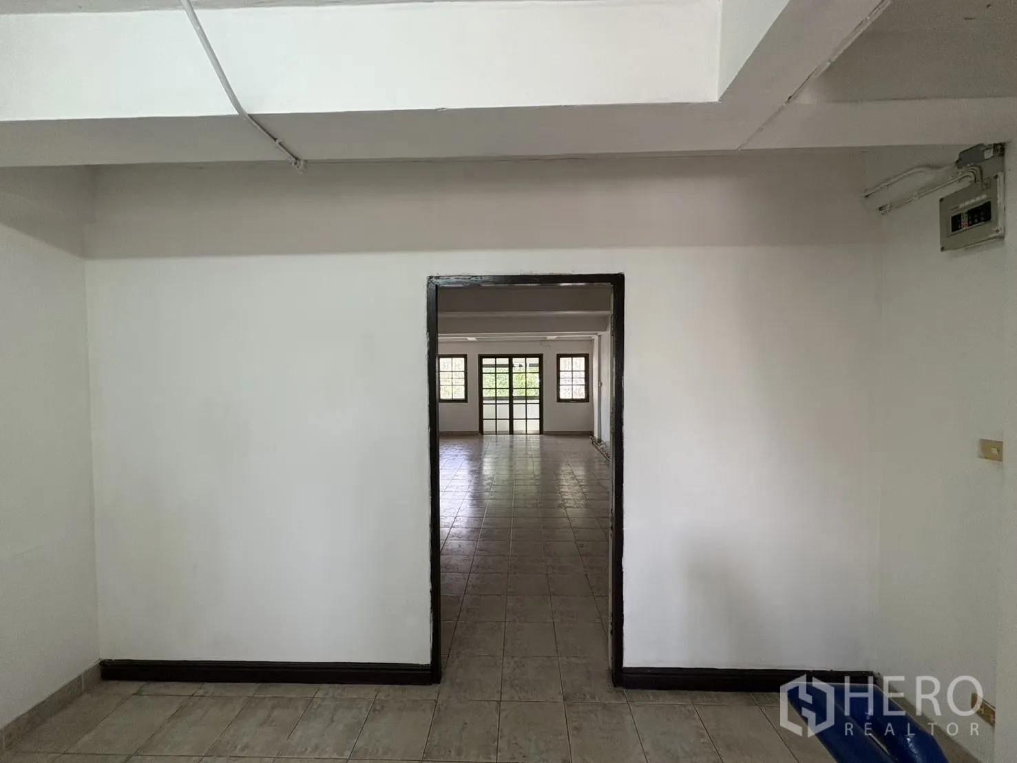 Shophouse for rent in Phra Khanong, Bangkok - Doorway leading to a bright, spacious room with tiled flooring and windows.
