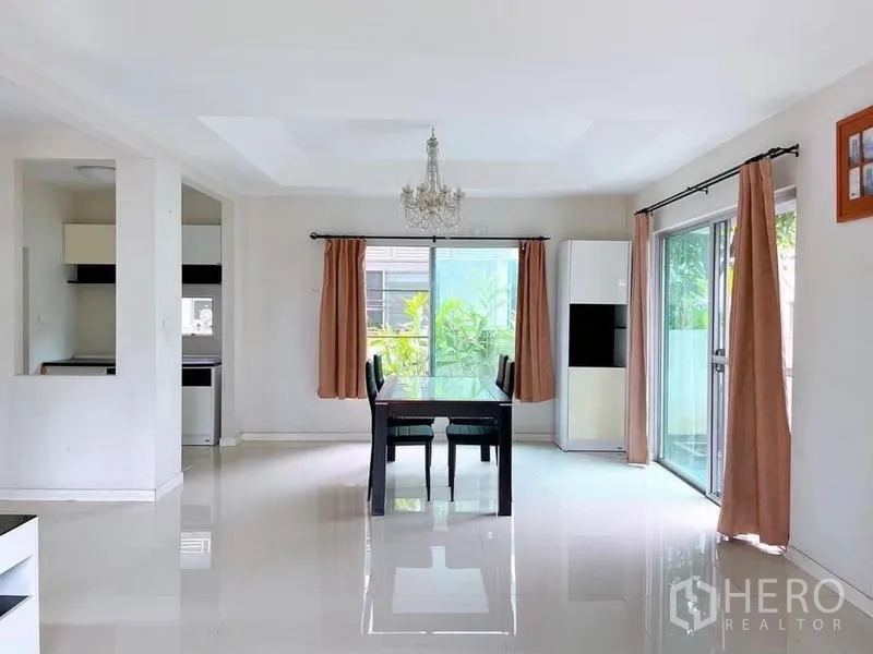 Detached House for rent in Bang Na, Bangkok - Dining space with dual sliding doors and garden view, polished tile floors.