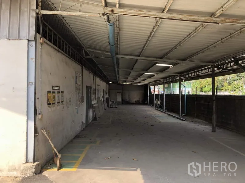 Warehouse for rent in Khlong Luang, Pathum Thani - Long covered side corridor for loading or parking next to the perimeter wall.