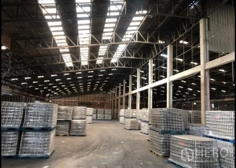 工厂 出租在Bang Khla, Chachoengsao - 超大仓库地面，天窗充足，托盘货物整齐堆放。