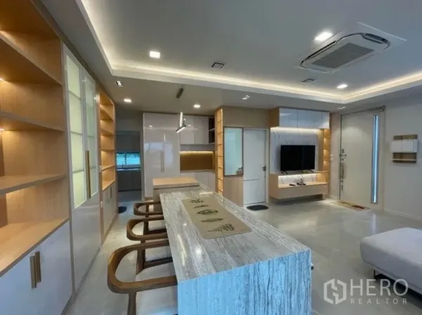 Detached House for rent in Prawet, Bangkok - Modern kitchen and long island breakfast bar with ample cabinetry and warm accent lighting.