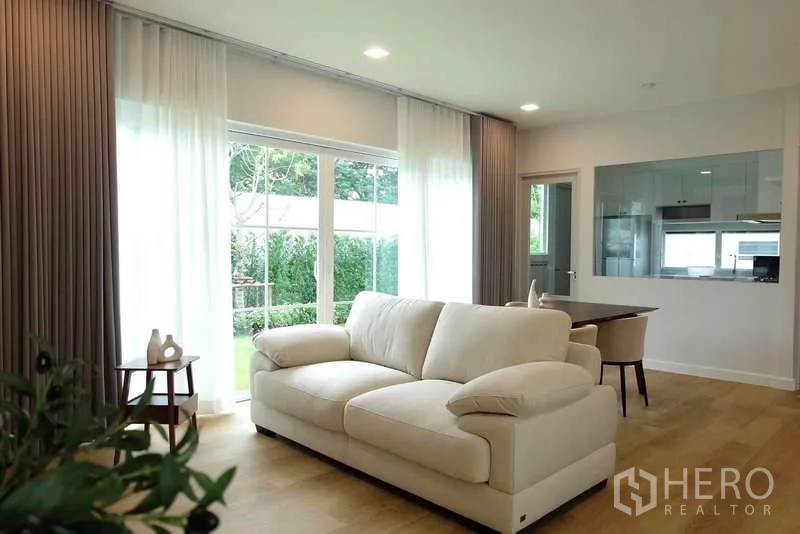 Detached House for rent in Bang Phli, Samut Prakan - Bright living area with cream sofa, large windows and view to garden.