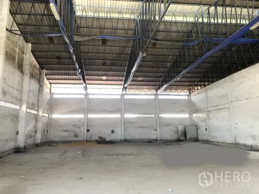 Warehouse for rent in Bang Phli, Samut Prakan - Spacious warehouse interior with high steel-truss roof, clerestory vents and concrete floor in Bang Phli.