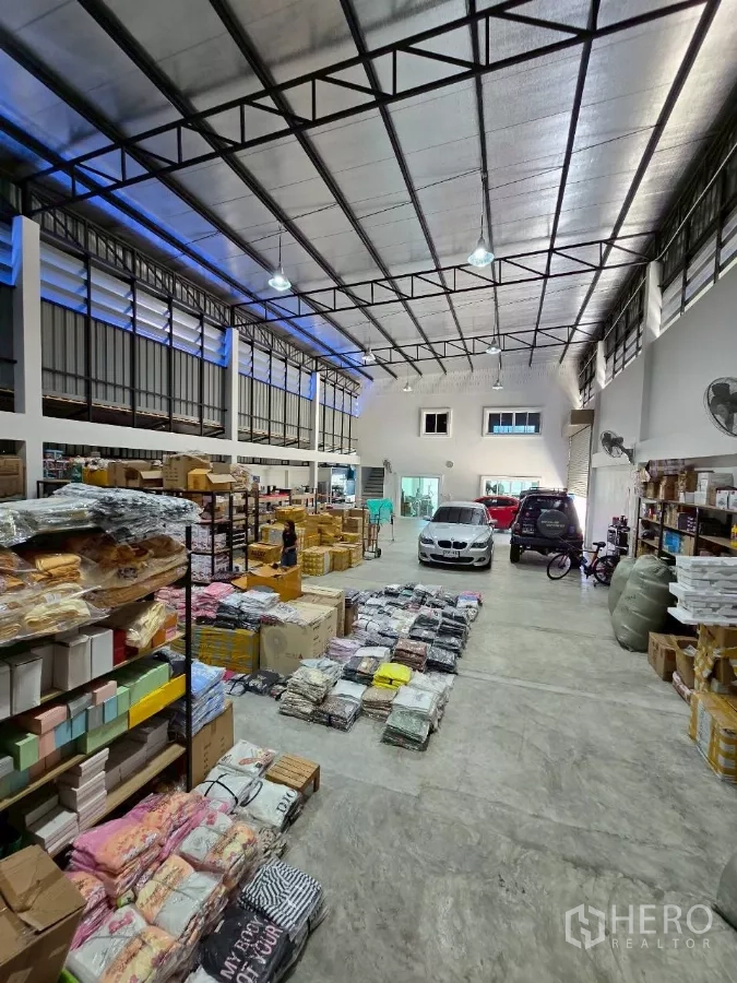 Warehouse for rent or sale in Khlong Toei, Bangkok - Spacious high-ceiling warehouse interior with steel truss roof, shelving and loading area.