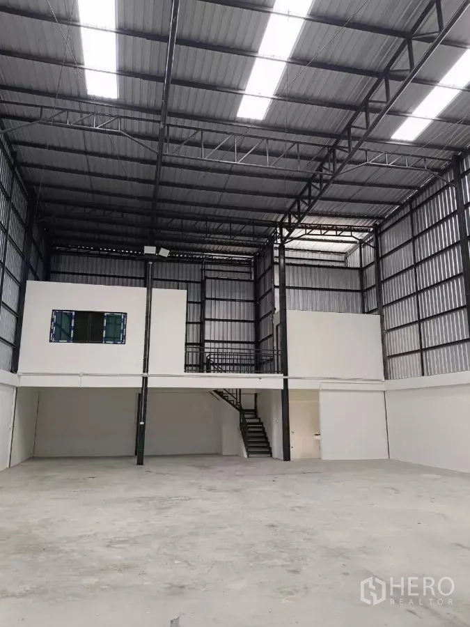 Warehouse for rent in Khlong Toei, Bangkok - Open-plan interior facing the mezzanine, showing lighting and steel structure.