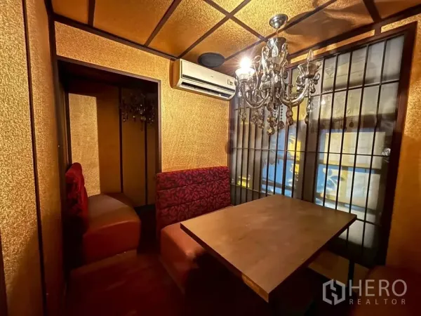 Shophouse for rent in Watthana, Bangkok - Small private booth with chandelier, gold walls and shoji-style windows.
