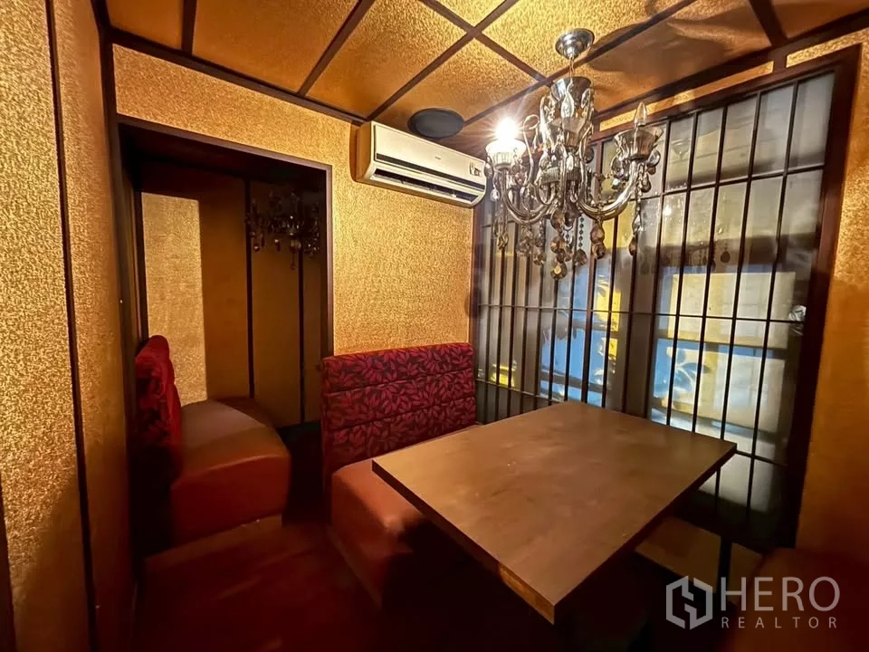 Shophouse for rent in Watthana, Bangkok - Small private booth with chandelier, gold walls and shoji-style windows.