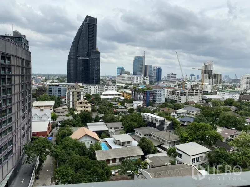 Condominium for rent in Khlong Toei, Bangkok - High-floor balcony view of the Bangkok skyline with towers and green low-rise neighborhood