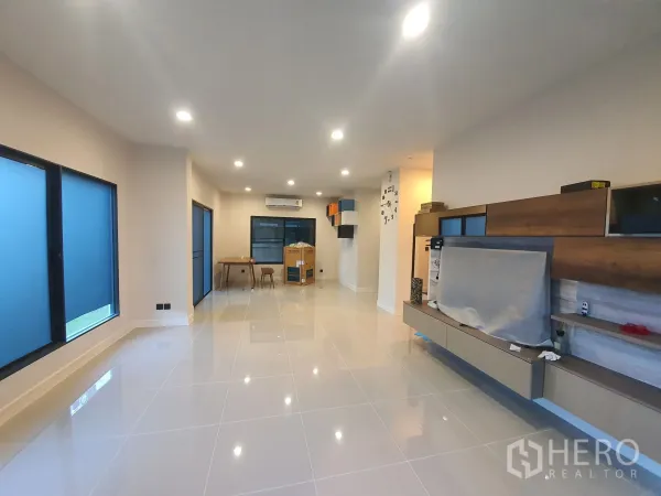 Detached House for rent in Bang Kapi, Bangkok - Bright open-plan living area with glossy tile floors and built-in wall shelves.