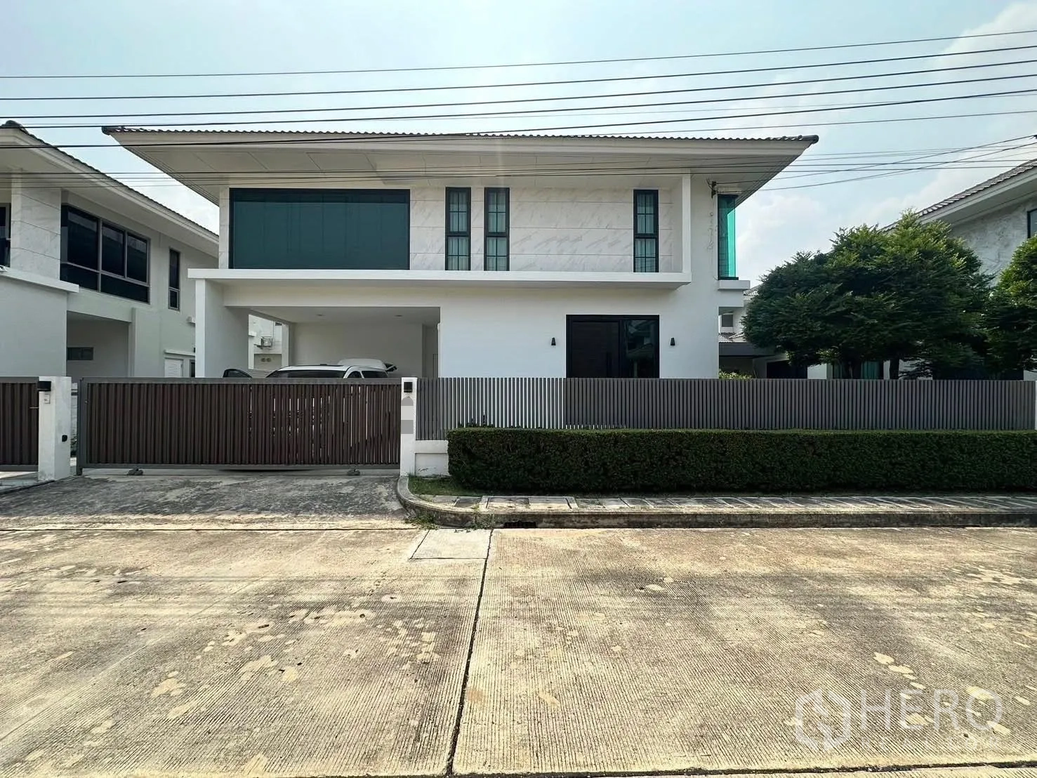 独立式住宅 出租在Lat Krabang, Bangkok - 现代两层独栋住宅，带围栏车库与绿篱。