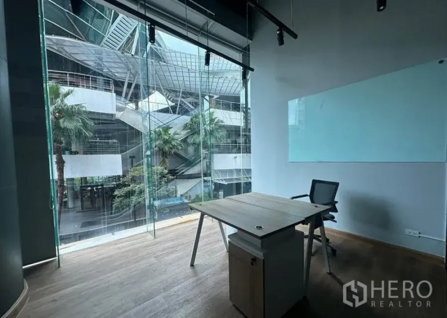 Office Space for rent - Private 14 sqm workspace with glass whiteboard, track lighting and a panoramic window with palm-tree view.