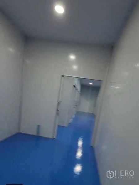 Factory for rent in Lam Luk Ka, Pathum Thani - Bright hallway with LED downlights and doorways to partitioned production rooms.