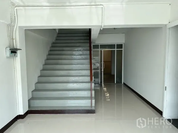 Factory for rent in Bang Sao Thong, Samut Prakan - Ground-floor lobby area with staircase and a glass-partitioned office entrance.