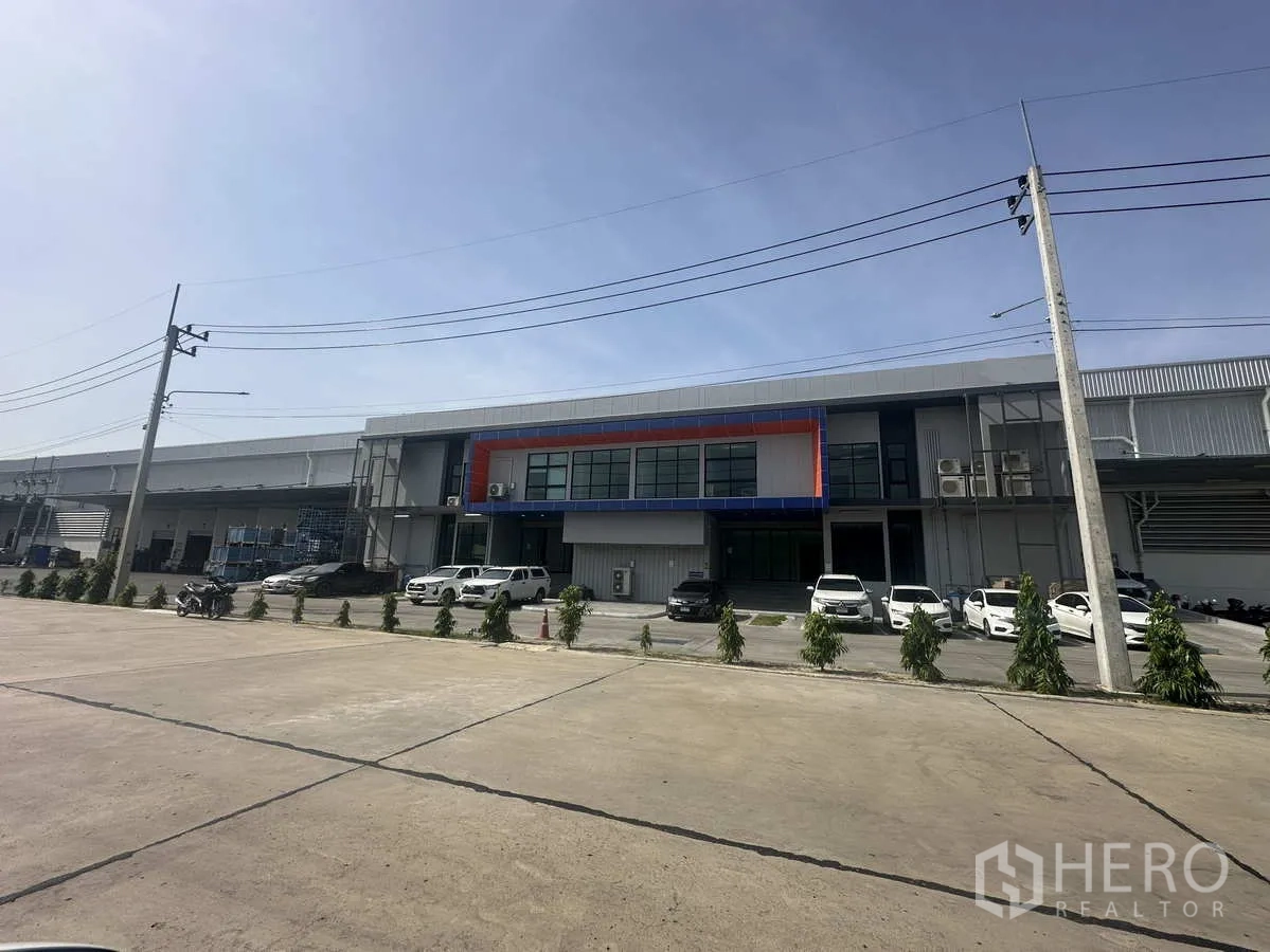 货栈 出租在Khlong Luang, Pathum Thani - 现代物流仓库外观，正面办公区、停车位与装卸区，临宽阔道路