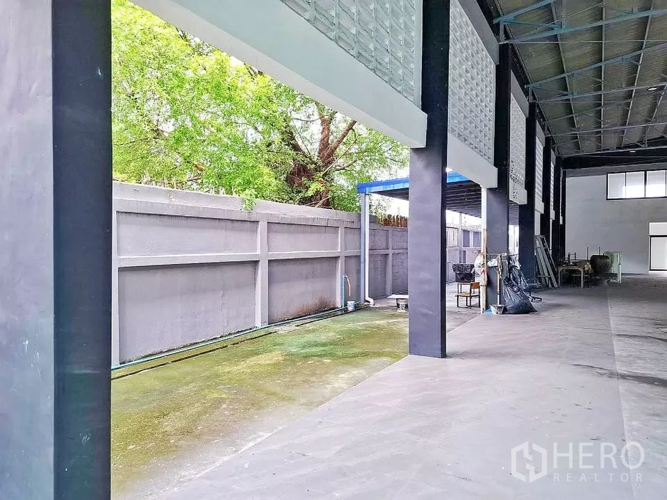 Warehouse for rent in Bang Kapi, Bangkok - Covered side bay and service strip along the warehouse with high boundary wall and drainage.