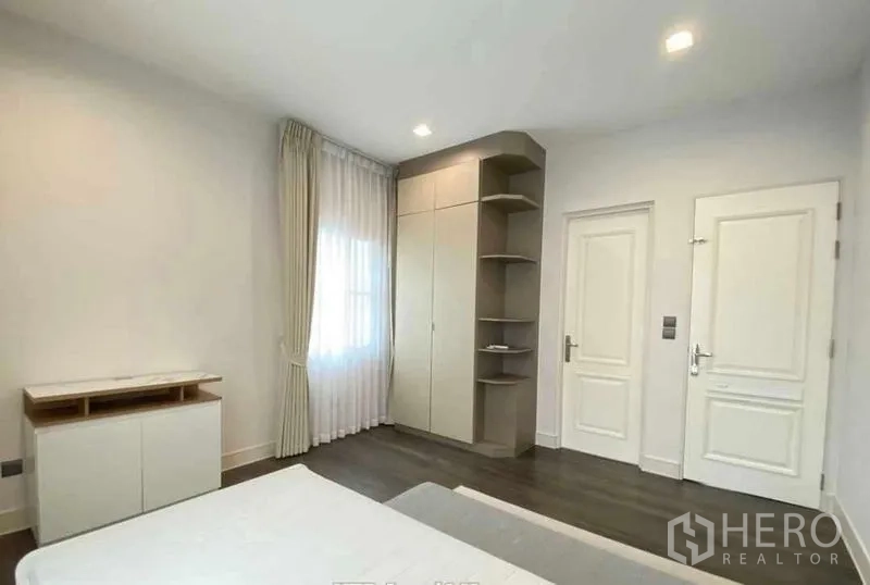独立式住宅 出租在Bang Khen, Bangkok - 卧室配内置衣柜与开放搁架，色调明亮。
