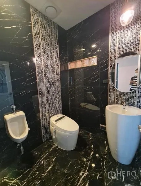独立式住宅 出售在Sai Mai, Bangkok - 深色大理石卫浴，立式台盆、马桶与小便斗。