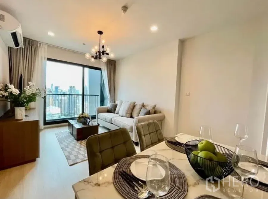 Condominium for rent in Pathum Wan, Bangkok - Open-plan living and dining room with marble table, sofa, and balcony city view in a Pathum Wan condo.