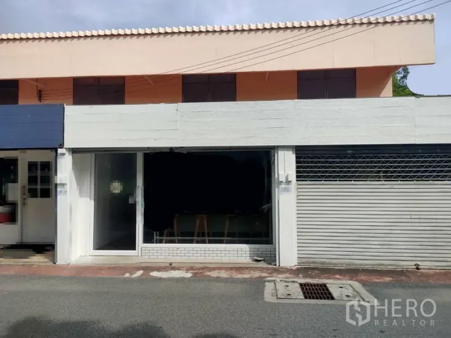 Retail Space for rent in Khlong Toei, Bangkok - Street-facing two-storey shopfront with full-height glass window and metal roller shutter.