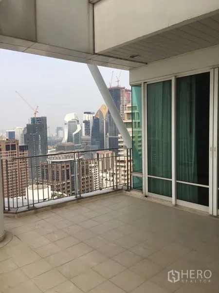 Condominium for rent or sale in Pathum Wan, Bangkok - Private balcony with railing overlooking Bangkok’s high‑rise skyline from an upper floor.