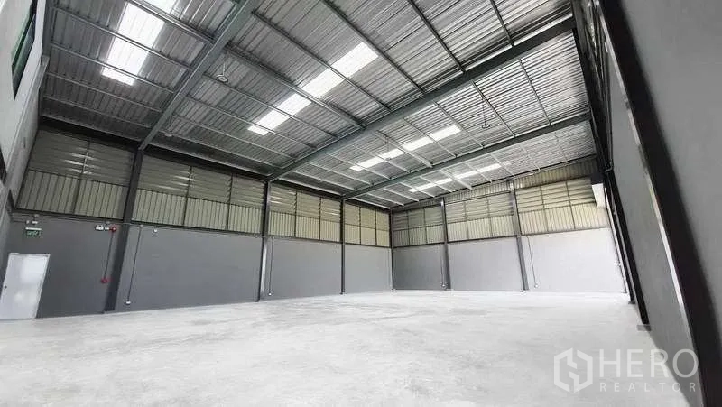 工厂 出租或出售在Bang Bo, Samut Prakan - 仓库内部视角，高挑通跨钢结构屋顶与抛光混凝土地面，适合卡车作业与货架。