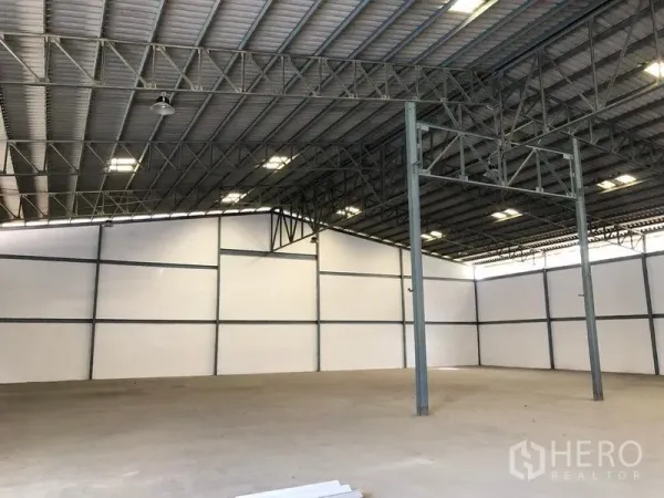 Warehouse for rent in Khlong Luang, Pathum Thani - Spacious warehouse interior with high steel truss roof, bright lighting and smooth concrete floor.