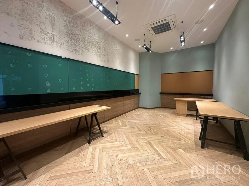 Office Space for rent - Office room with herringbone wood flooring, long built-in cabinetry and a green glass writing board.