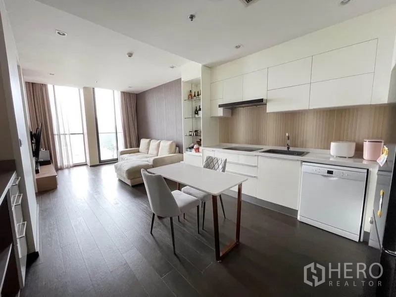 Condominium for rent in Pathum Wan, Bangkok - Contemporary open living, dining, and kitchen zone in neutral tones with tall windows.