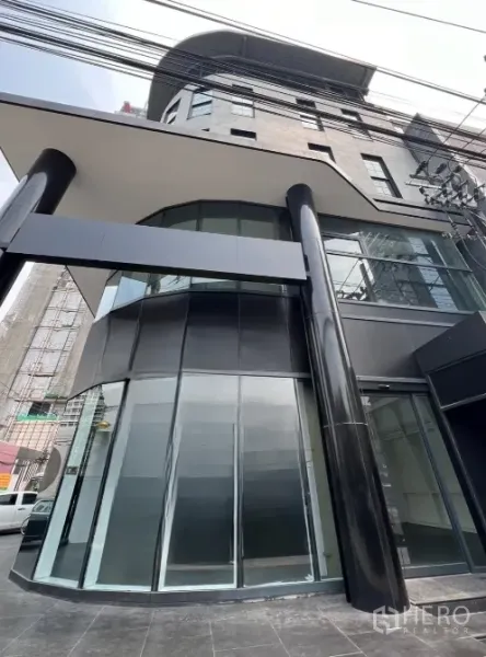 Retail Space for rent in Watthana, Bangkok - Angled view of the corner glass frontage and canopy of a contemporary retail property with strong signage visibility.