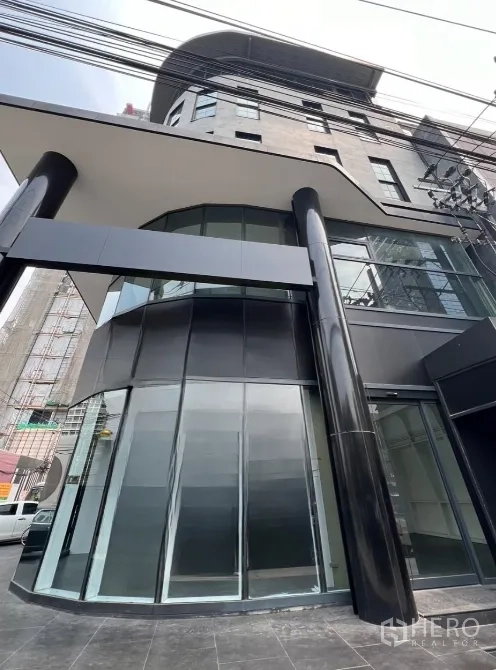 Retail Space for rent in Watthana, Bangkok - Angled view of the corner glass frontage and canopy of a contemporary retail property with strong signage visibility.