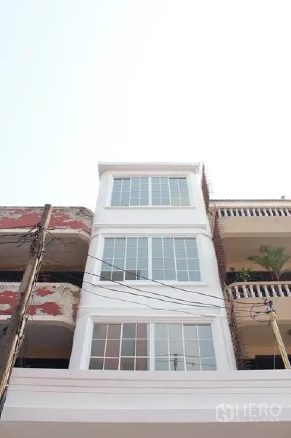 带办公室的家 出租在Khlong Toei, Bangkok - 白色四层居家办公楼外立面，配大面积网格窗