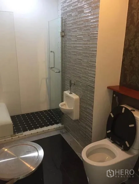 联排别墅 出租在Prawet, Bangkok - 现代浴室，玻璃淋浴间，墙面瓷砖，坐便器与小便器。