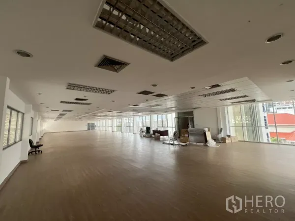 Office Space for rent in Watthana, Bangkok - Spacious open-plan office floor with wood-look flooring, drop ceiling and large windows in Watthana.