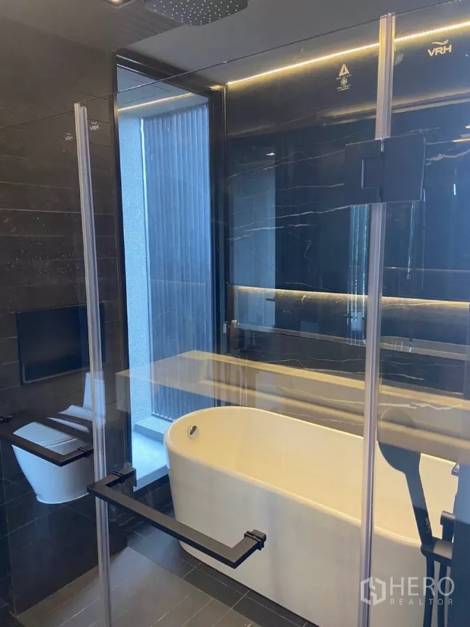 Townhouse for rent in Huai Khwang, Bangkok - Glass-enclosed bathroom featuring a freestanding tub and overhead rain shower.